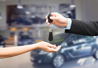 Image showing close up of customer and salesman with car key