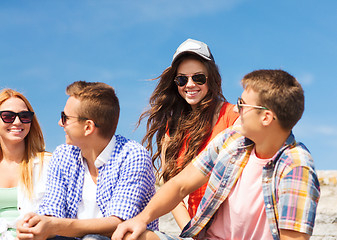 Image showing group of smiling friends sitting on city street