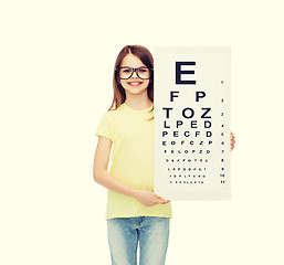 Image showing little girl in eyeglasses with eye checking chart