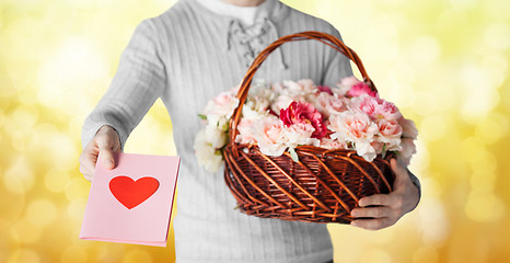 Image showing man holding basket full of flowers and postcard