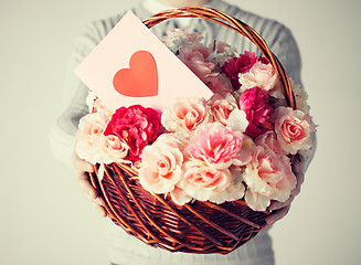 Image showing man holding basket full of flowers and postcard