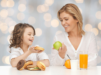 Image showing happy mother and daughter eating breakfast