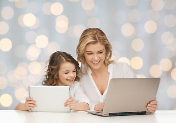 Image showing mother with girl looking to laptop and tablet pc