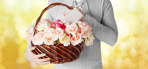 Image showing man holding basket full of flowers and postcard