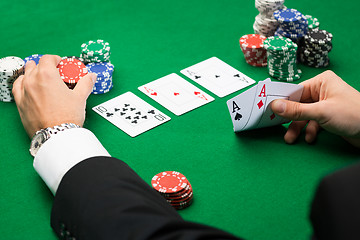 Image showing poker player with cards and chips at casino