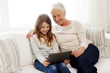 Image showing smiling family with tablet pc at home