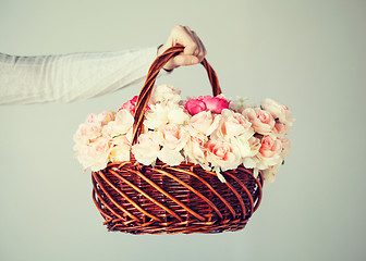 Image showing man's hand holding basket full of flowers