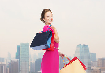 Image showing young happy woman with shopping bags over city