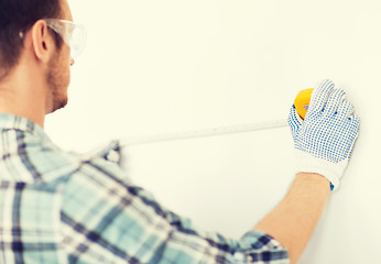 Image showing architect measuring wall with flexible ruler