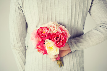 Image showing man hiding bouquet of flowers