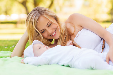 Image showing happy mother lying with little baby on blanket
