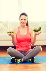 Image showing smiling teenager with green salad and hamburger