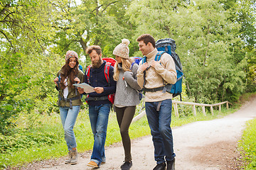 Image showing group of smiling friends with backpacks hiking