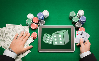 Image showing casino poker player with cards, tablet and chips