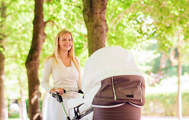 Image showing happy mother with stroller in park