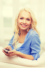 Image showing smiling woman with smartphone at home