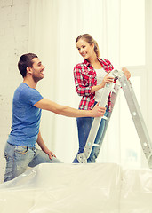 Image showing smiling couple hanging curtains