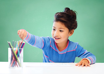 Image showing happy school girl drawing with coloring pencils