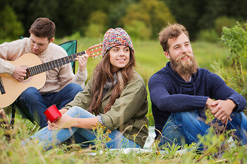 Image showing group of smiling friends with guitar outdoors