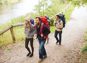 Image showing group of smiling friends with backpacks hiking