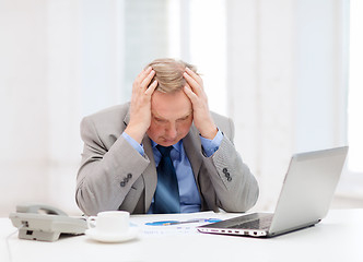 Image showing upset older businessman with laptop and telephone