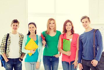 Image showing smiling students with bags and folders at school