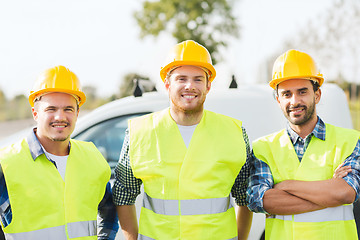 Image showing group of smiling builders in hardhats outdoors