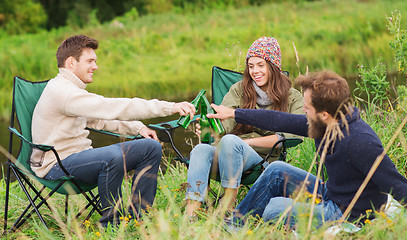 Image showing group of smiling tourists drinking beer in camping