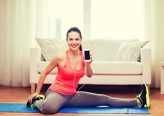 Image showing smiling teenage girl streching on floor at home