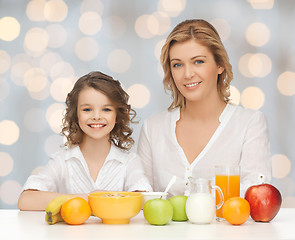 Image showing happy mother and daughter eating breakfast