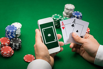 Image showing casino player with cards, smartphone and chips