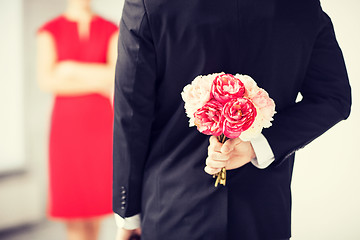 Image showing man hiding bouquet of flowers