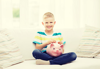 Image showing smiling little boy with piggy bank and money