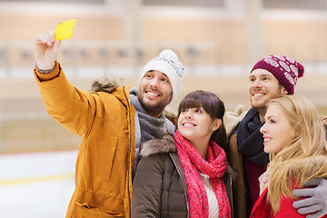 Image showing happy friends taking selfie on skating rink