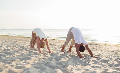 Image showing couple making yoga exercises outdoors