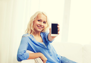 Image showing smiling woman with blank smartphone screen at home