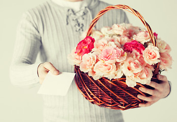 Image showing man holding basket full of flowers and postcard