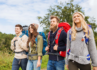 Image showing group of smiling friends with backpacks hiking