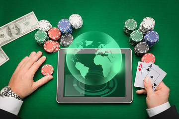 Image showing casino poker player with cards, tablet and chips