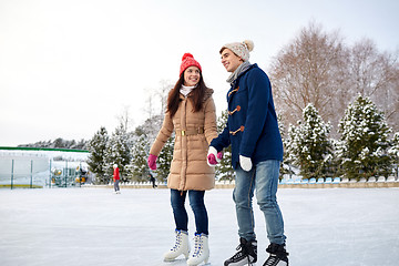 Image showing happy couple ice skating on rink outdoors