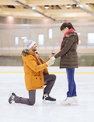 Image showing happy couple with engagement ring on skating rink