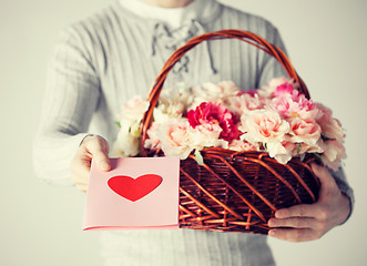 Image showing man holding basket full of flowers and postcard