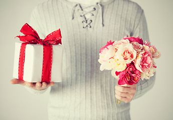 Image showing man holding bouquet of flowers and gift box