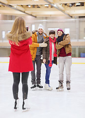 Image showing happy friends taking photo on skating rink