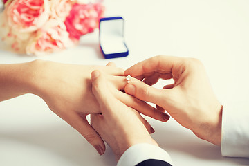 Image showing man putting  wedding ring on woman hand