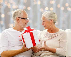 Image showing happy senior couple with gift box at home