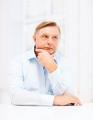 Image showing stressed old man holding head at home