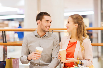 Image showing happy couple with shopping bags drinking coffee