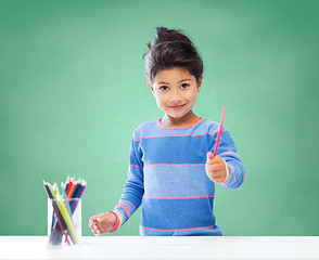 Image showing happy school girl drawing with coloring pencils