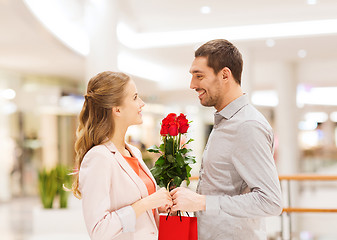 Image showing happy young couple with flowers in mall